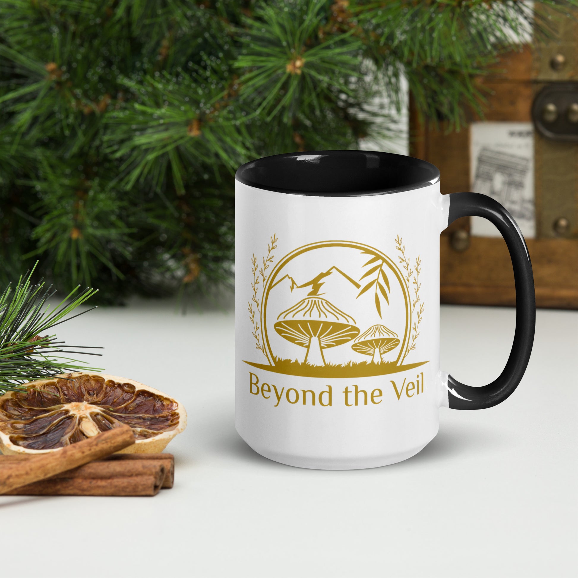 White mug with black interior and handle, featuring a gold logo and text 'Beyond the Veil' on a Christmas Background